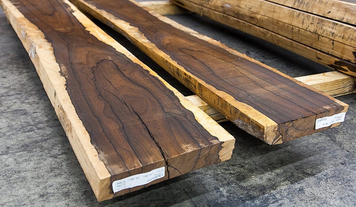 Rosewood lumber with sap wood edges and cathedral growth structure.